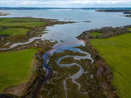 A bright red barrier across a channel of water.