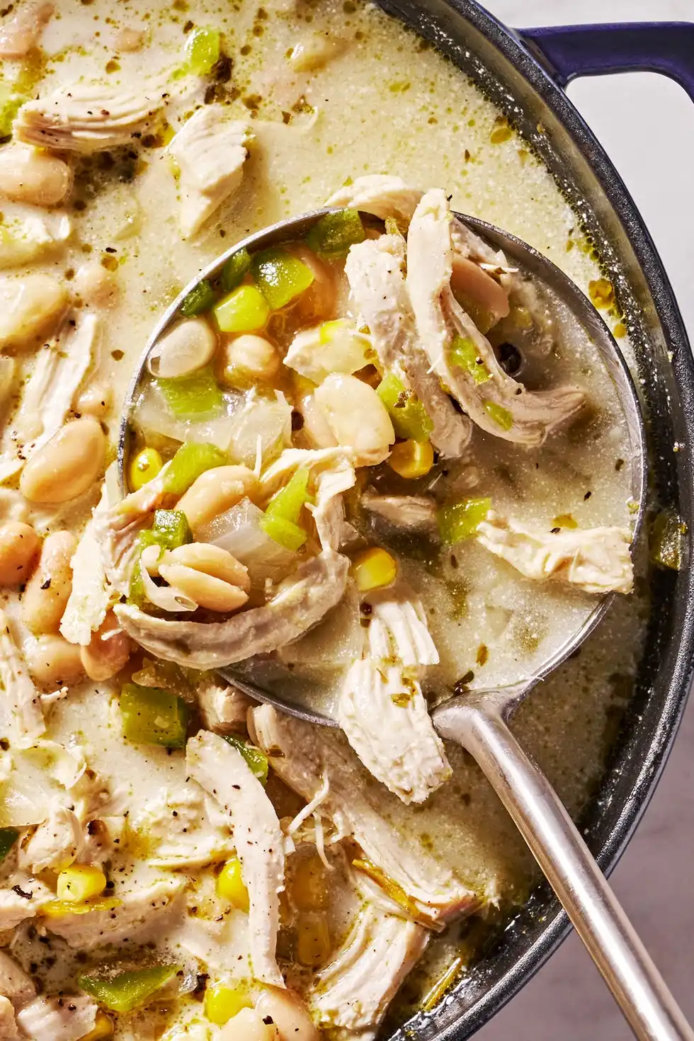 white chicken chili with cilantro, chips, sour cream and avocado