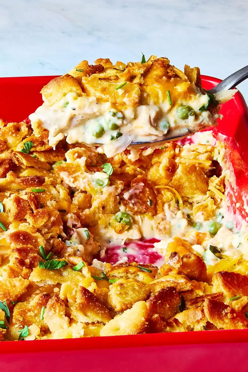 chicken casserole topped with ritz crackers in a red dish