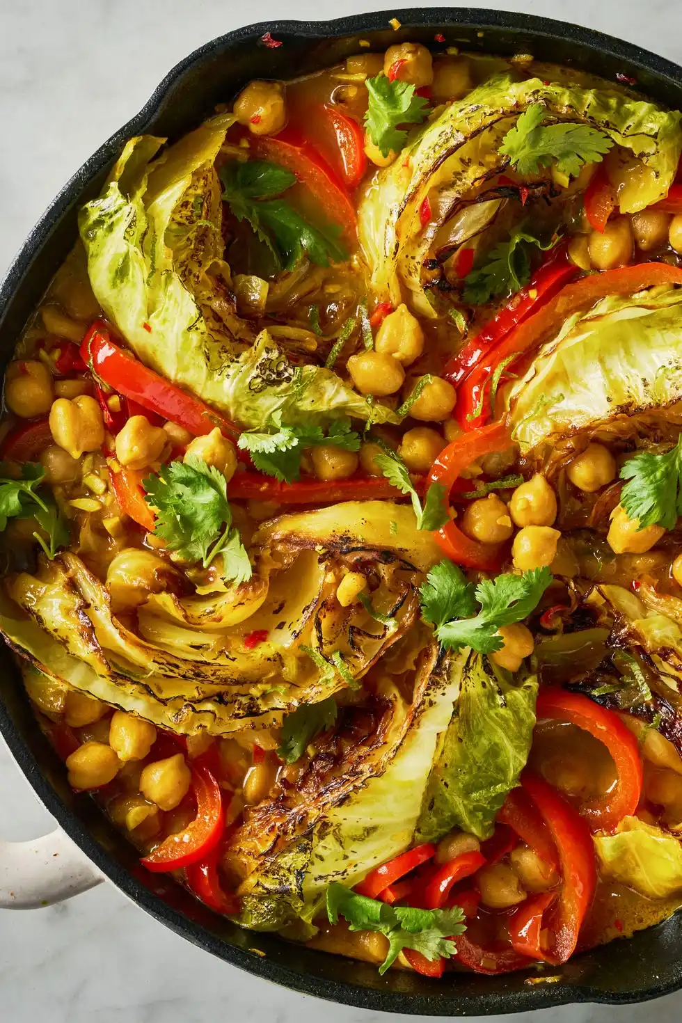 coconut braised cabbage with peppers and chickpeas in a skillet