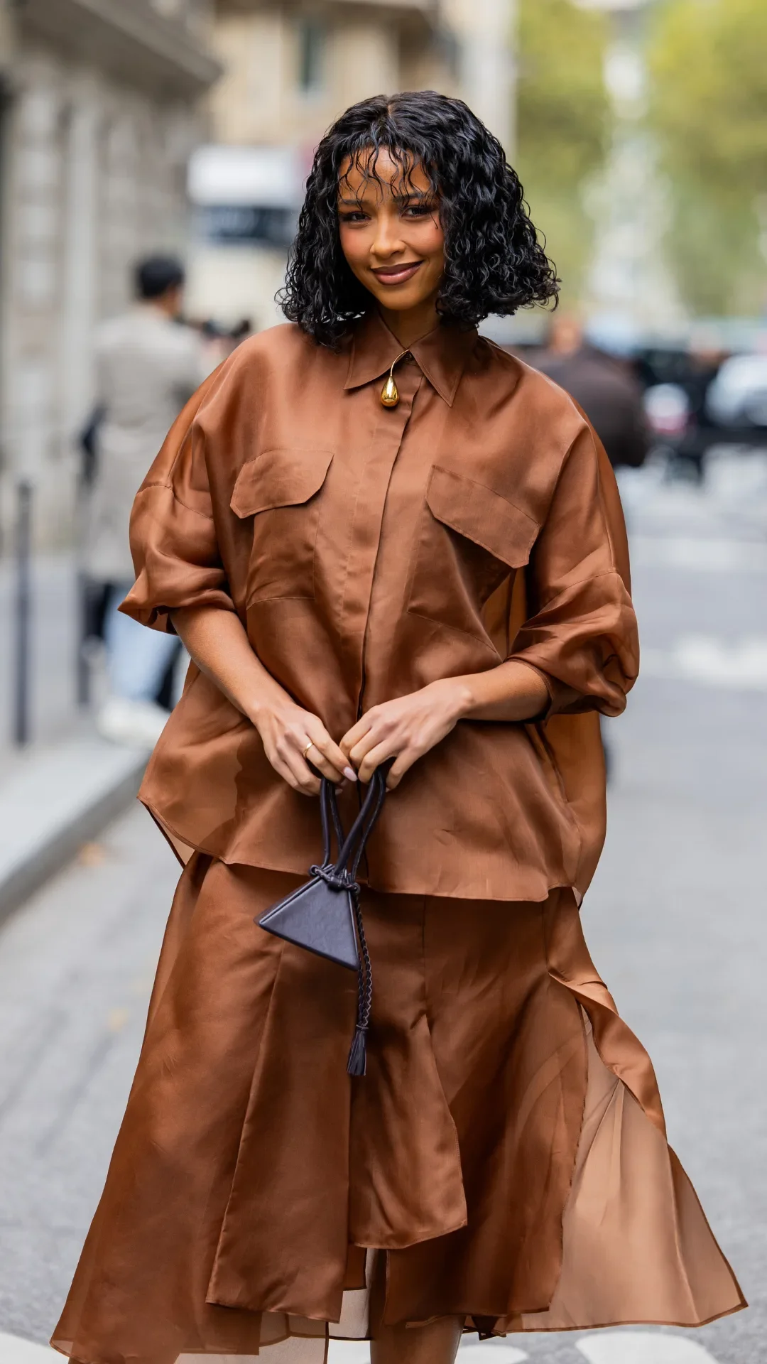 Flora Coquerel wears brown blouse, skirt, black bag outside Akris during Womenswear Spring/Summer 2025 as part of Paris Fashion Week on September 29, 2024 in Paris, France.