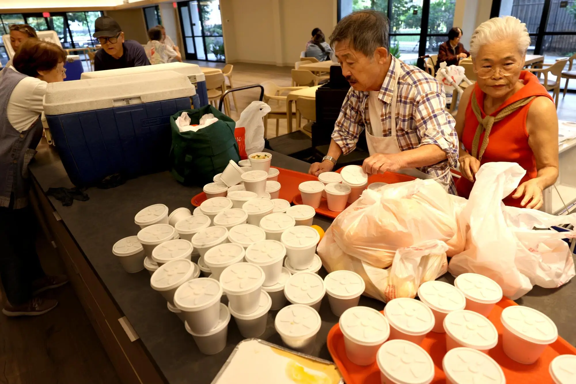 Yuji Katsumata and Yoshiko Becker prepare meals.