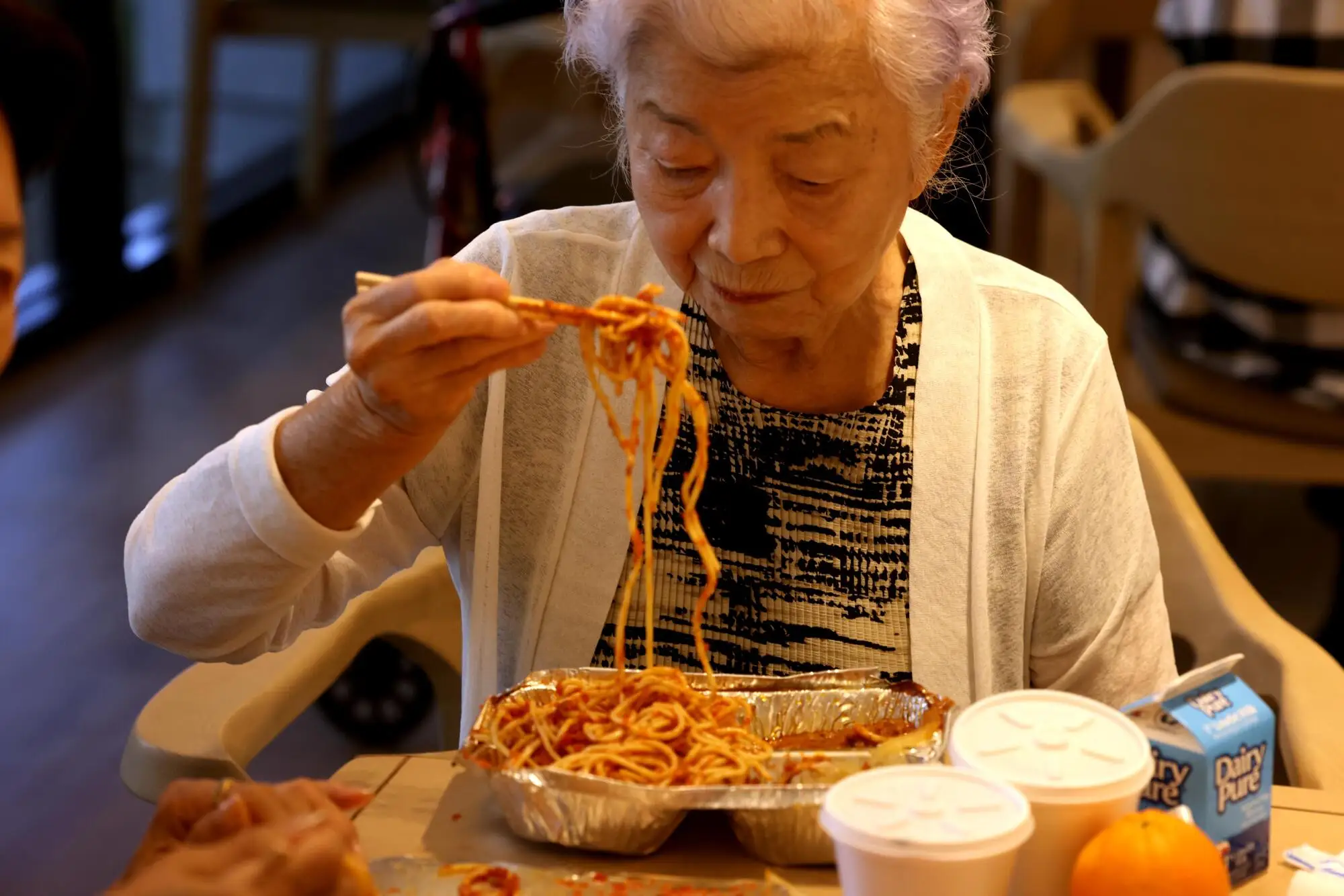 Sukhee Kim eats noodles using chopsticks