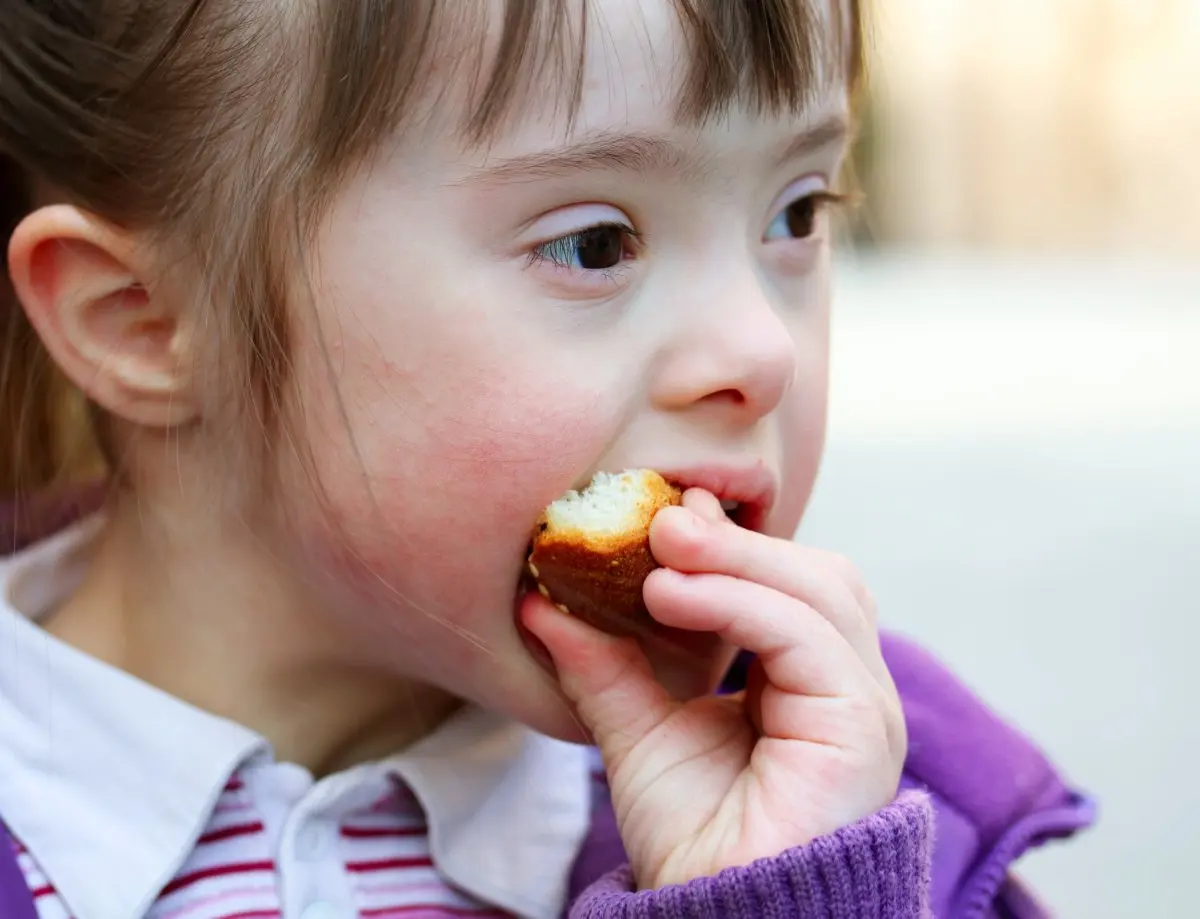 Portrait of girl with Down's syndrome eating