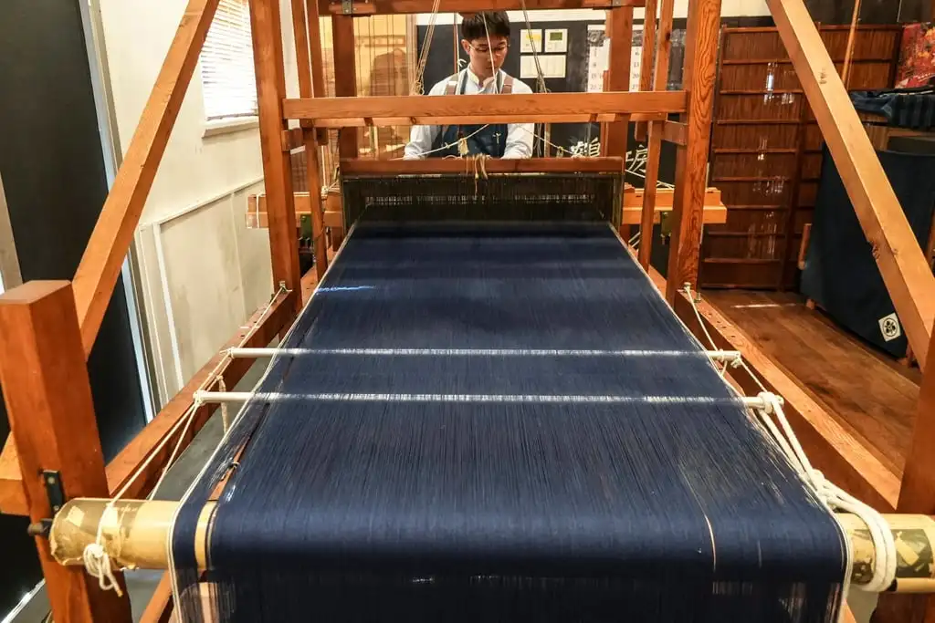 A weaver operates a handloom at Momotaro Jeans in Kojima. Photo: AP