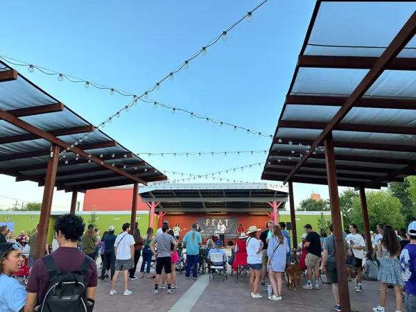 A photograph of a group of people gathered to hear a band play.