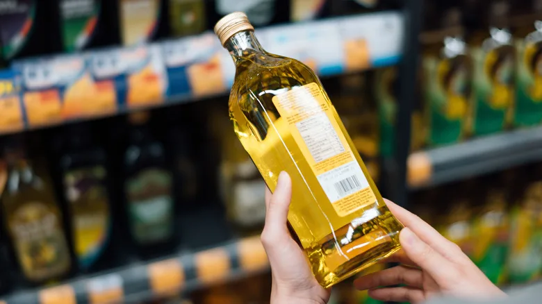 Woman holding olive oil bottle