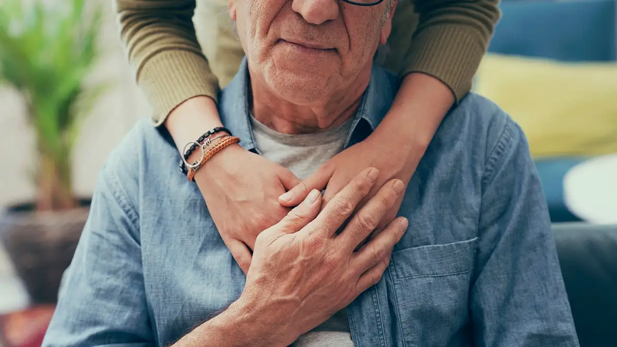 Comforting hand on shoulder of man