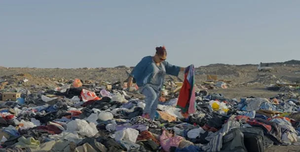 A woman on a pile of clothes in the Atacama dessert