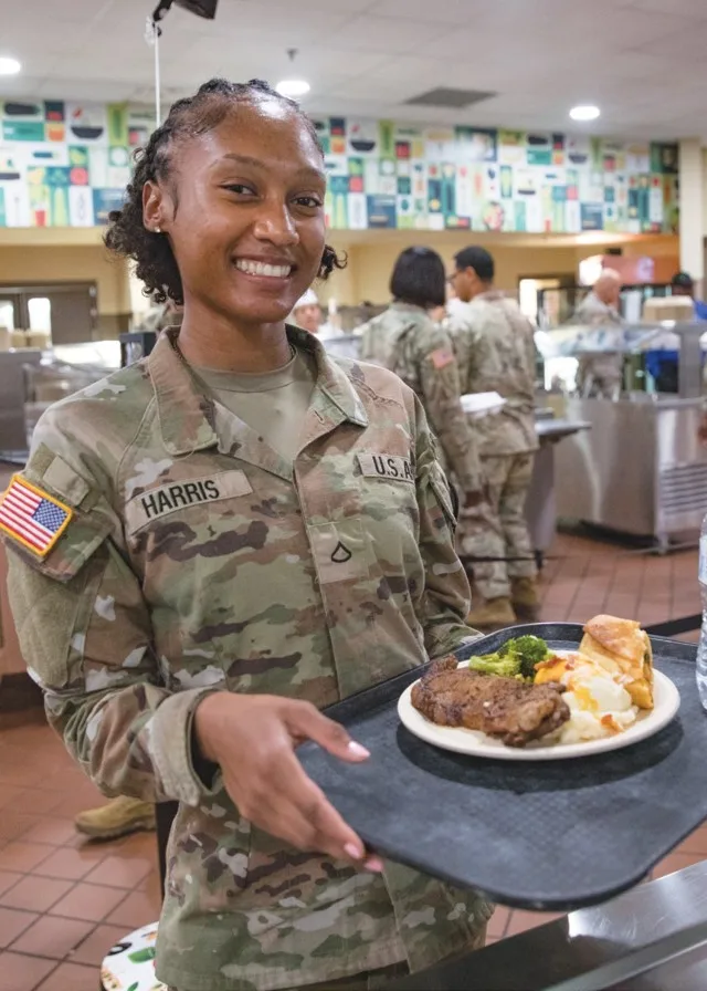 Pfc. Sieria Harris, 215th Brigade Support Battalion, poses with her steak, mashed potatoes, broccoli and roll she picked from the Headquarters Department of the Army Go for Green Action Station Oct. 9 at the Operation Iraqi Freedom Dining Facility...