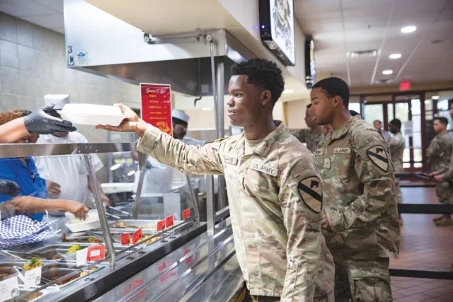 Pfc. Ishmiel Williams, 2nd Battalion, 7th Cavalry Regiment, 3rd Armored Brigade Combat Team, receives his lunch at the Headquarters Department of the Army Go for Green Action Station Oct. 9 at the Operation Iraqi Freedom Dining Facility at Fort...