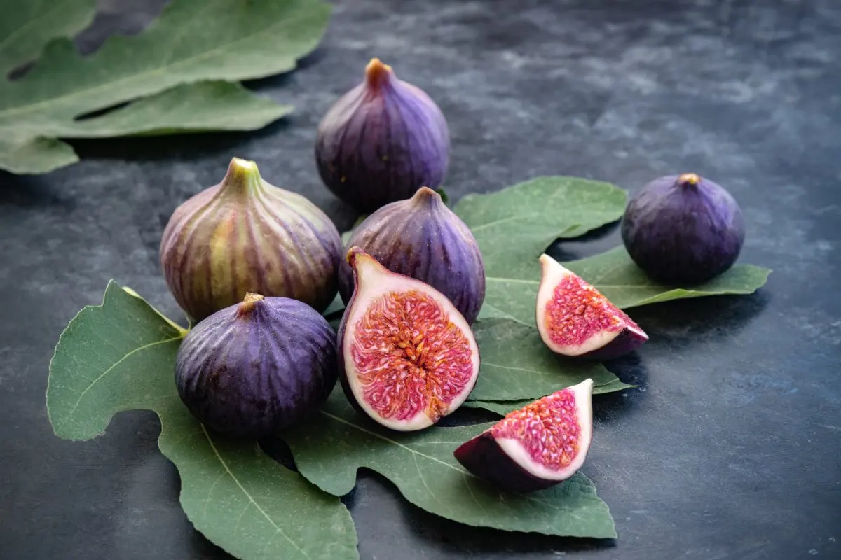 Whole and sliced figs on fig leaves