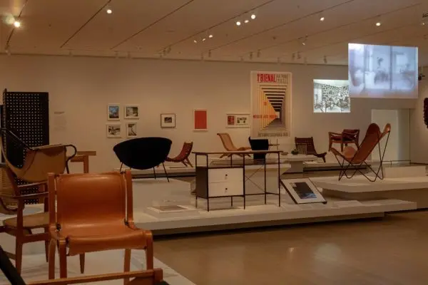 A room with chairs and framed artwork on display.