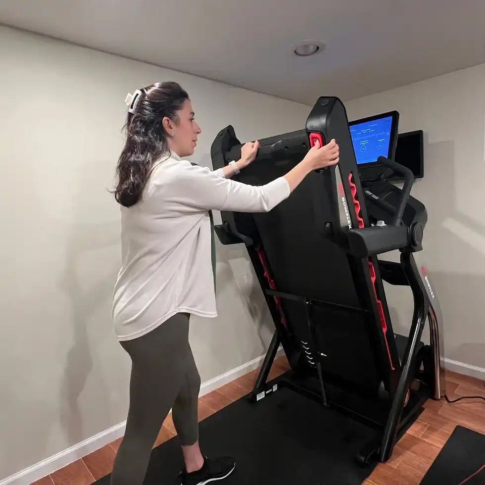 sassos folding the bowflex treadmill 22 in her home