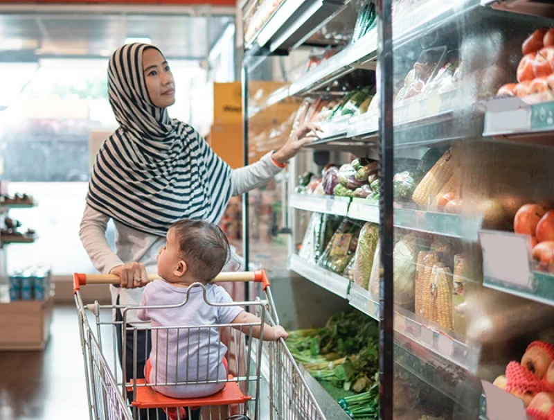 Woman and child grocery store shopping with cart