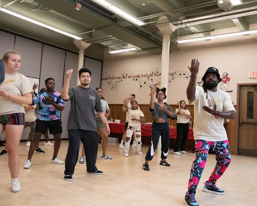 A group of students learn dance moves.