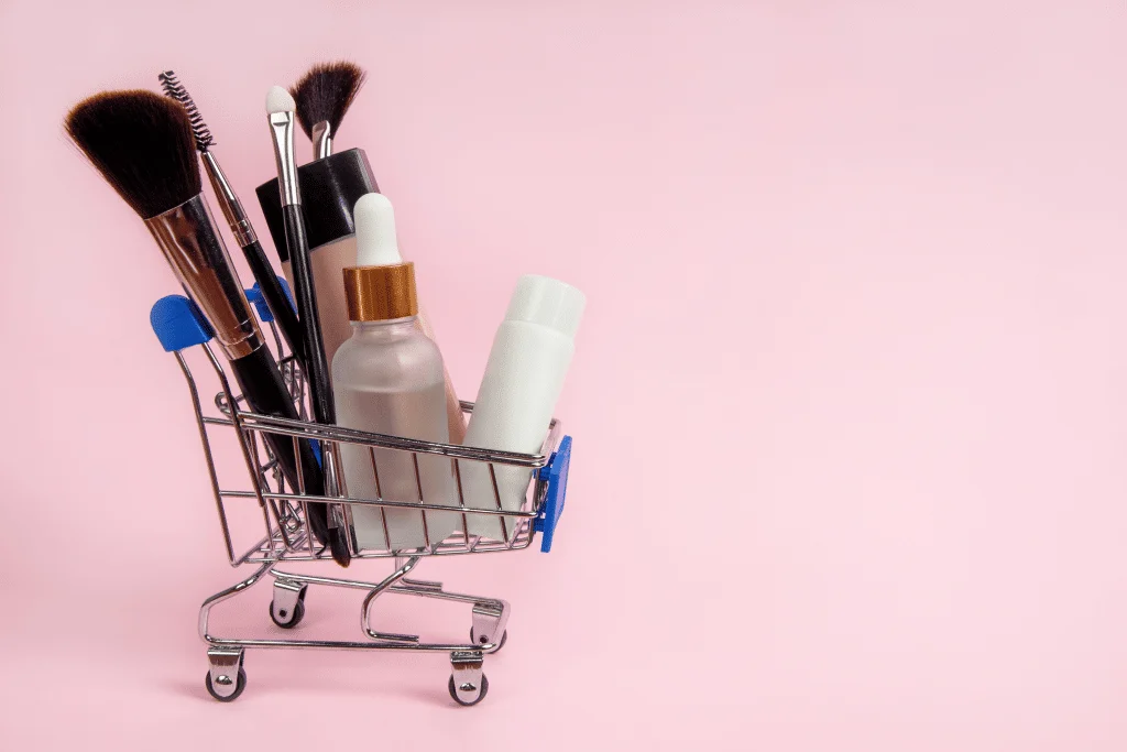 Natural base products such as primer and BB cream sitting in a miniature shopping cart. 