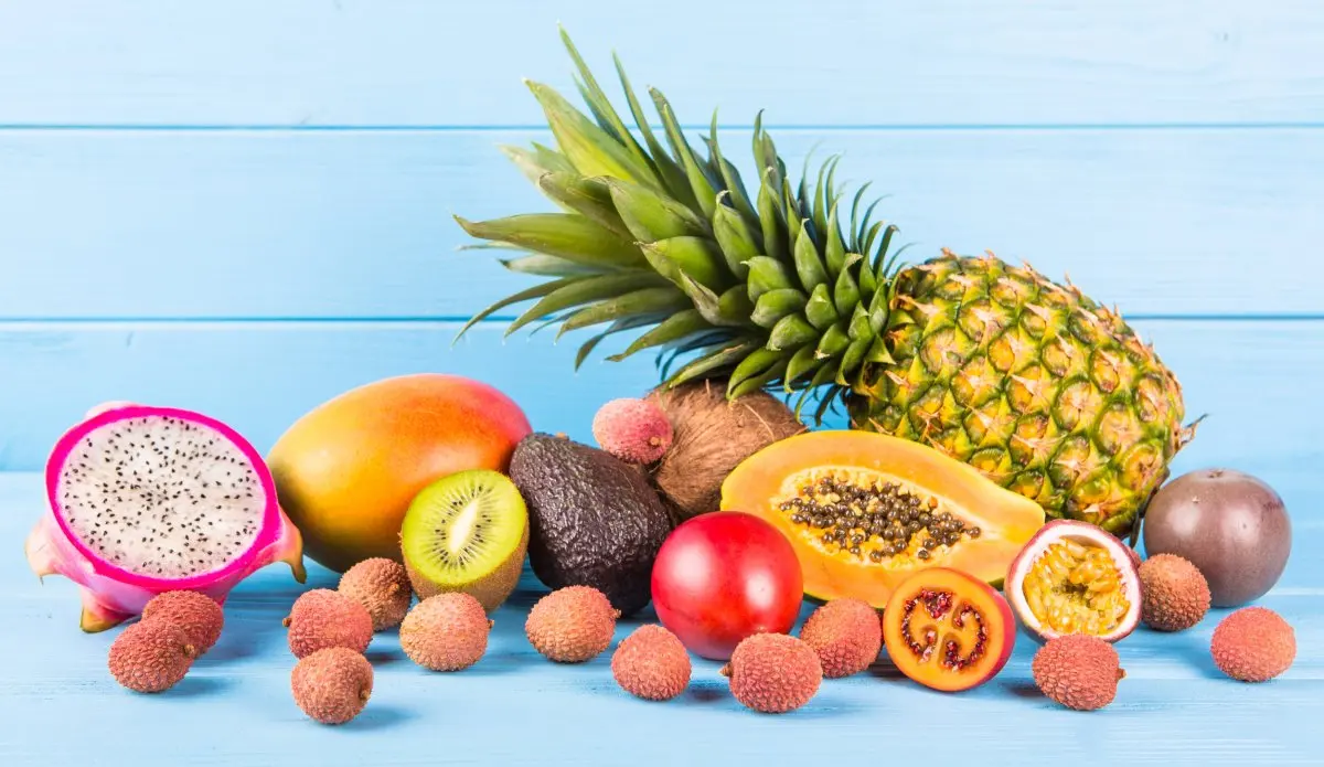 Fresh ripe fruit on blue wooden background