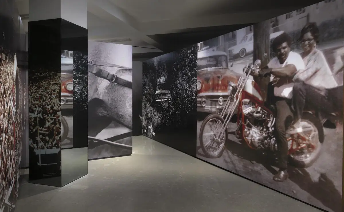 A large photo of a man and woman on a motorcycle on display in a room