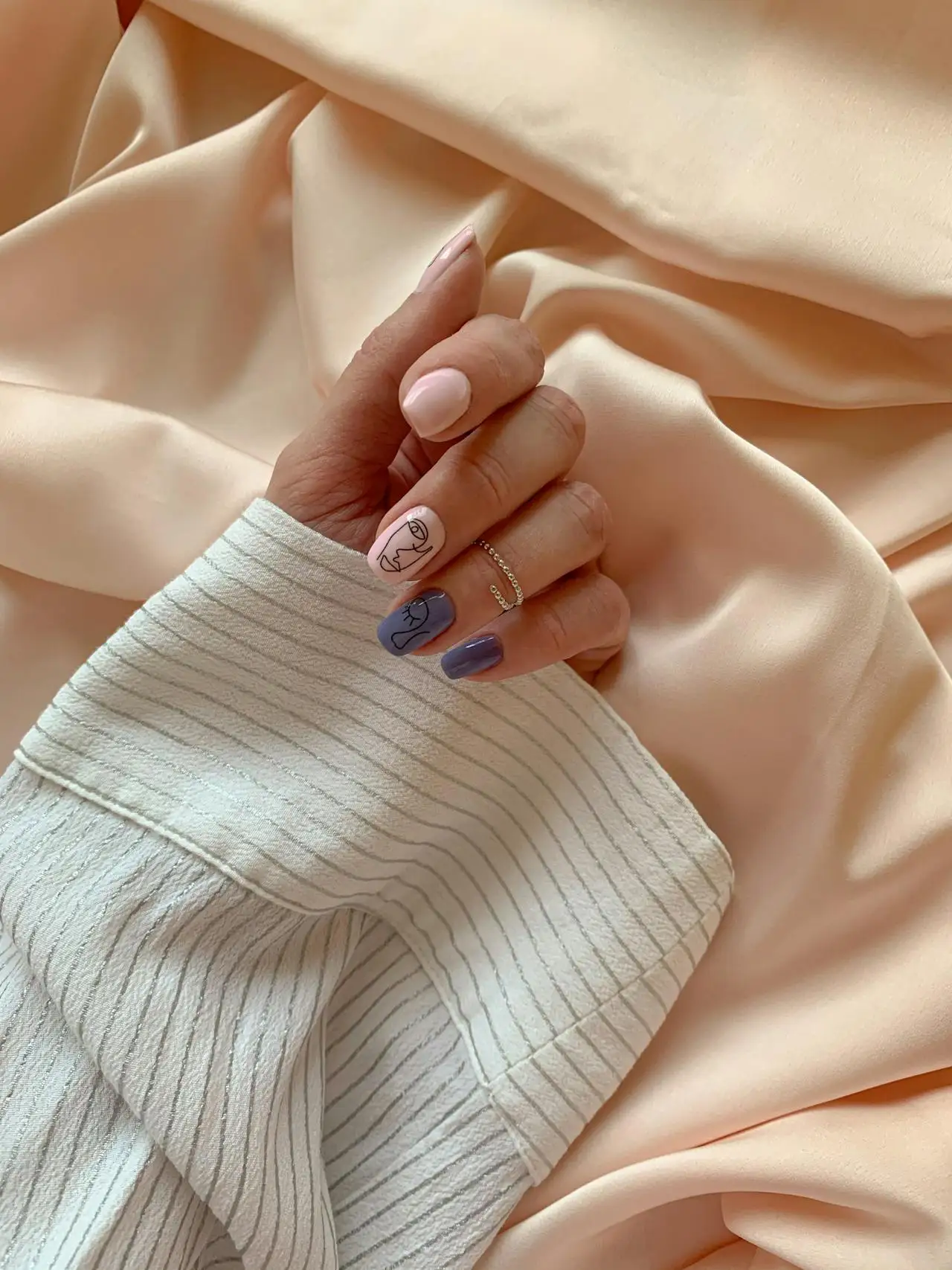 manicured nails on silk sheet