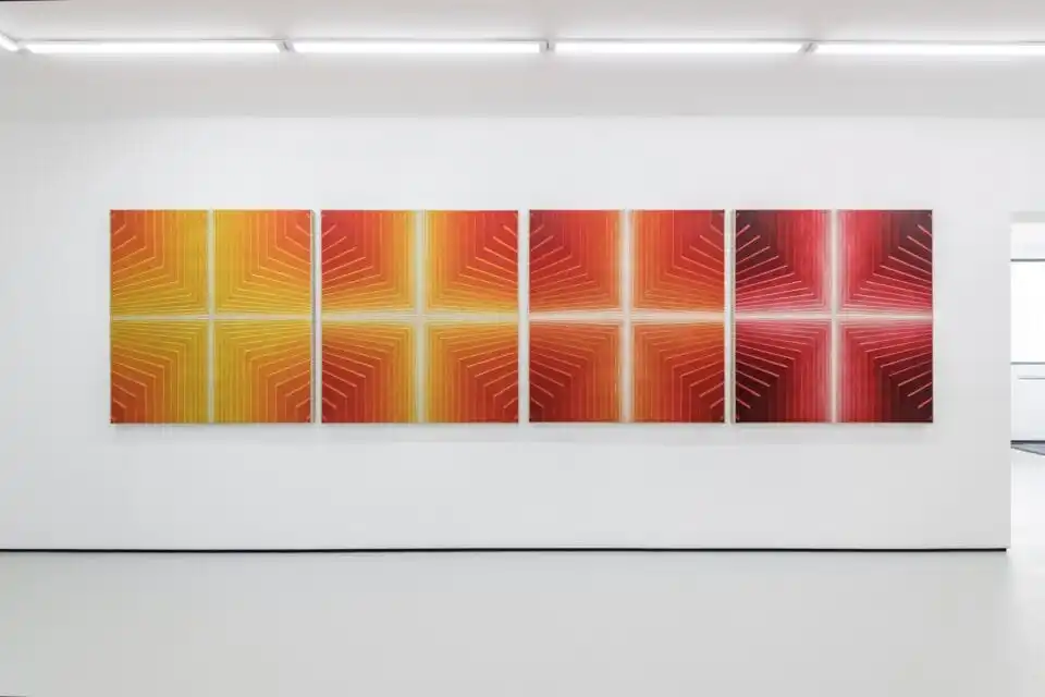 a series of four square canvases of bright red and yellow geometric abstract paintings