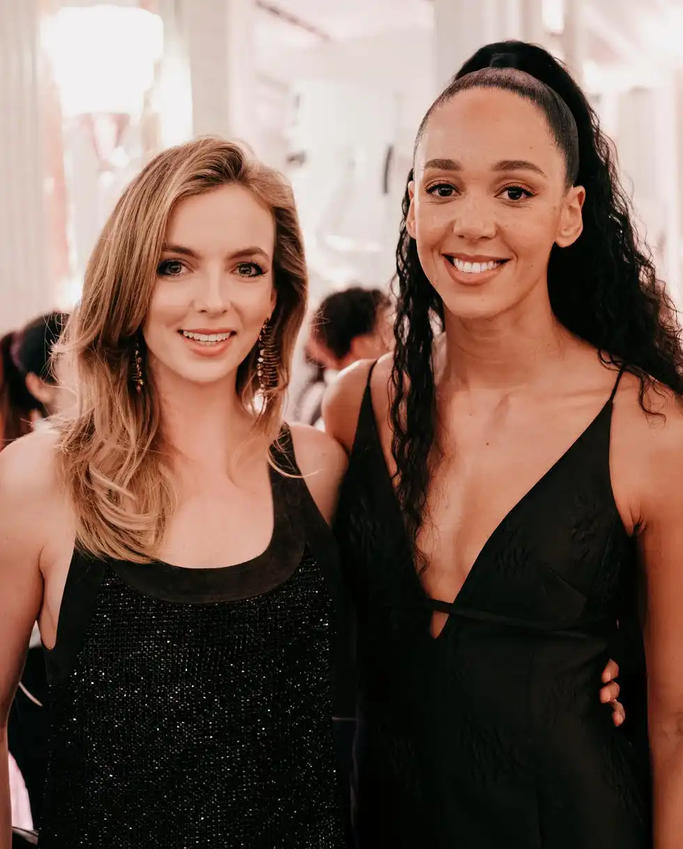 Two women in a social gathering dressed elegantly