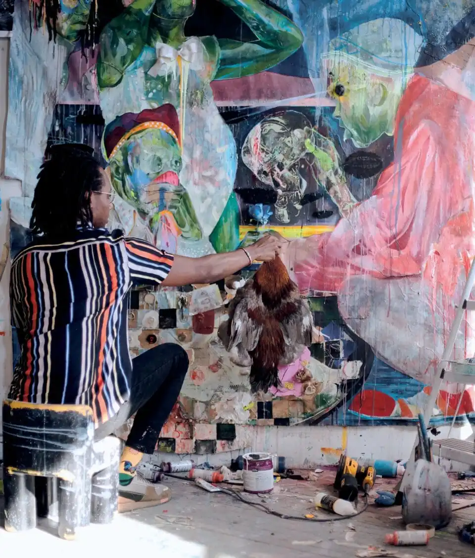 an artist in her studio painting on a canvas