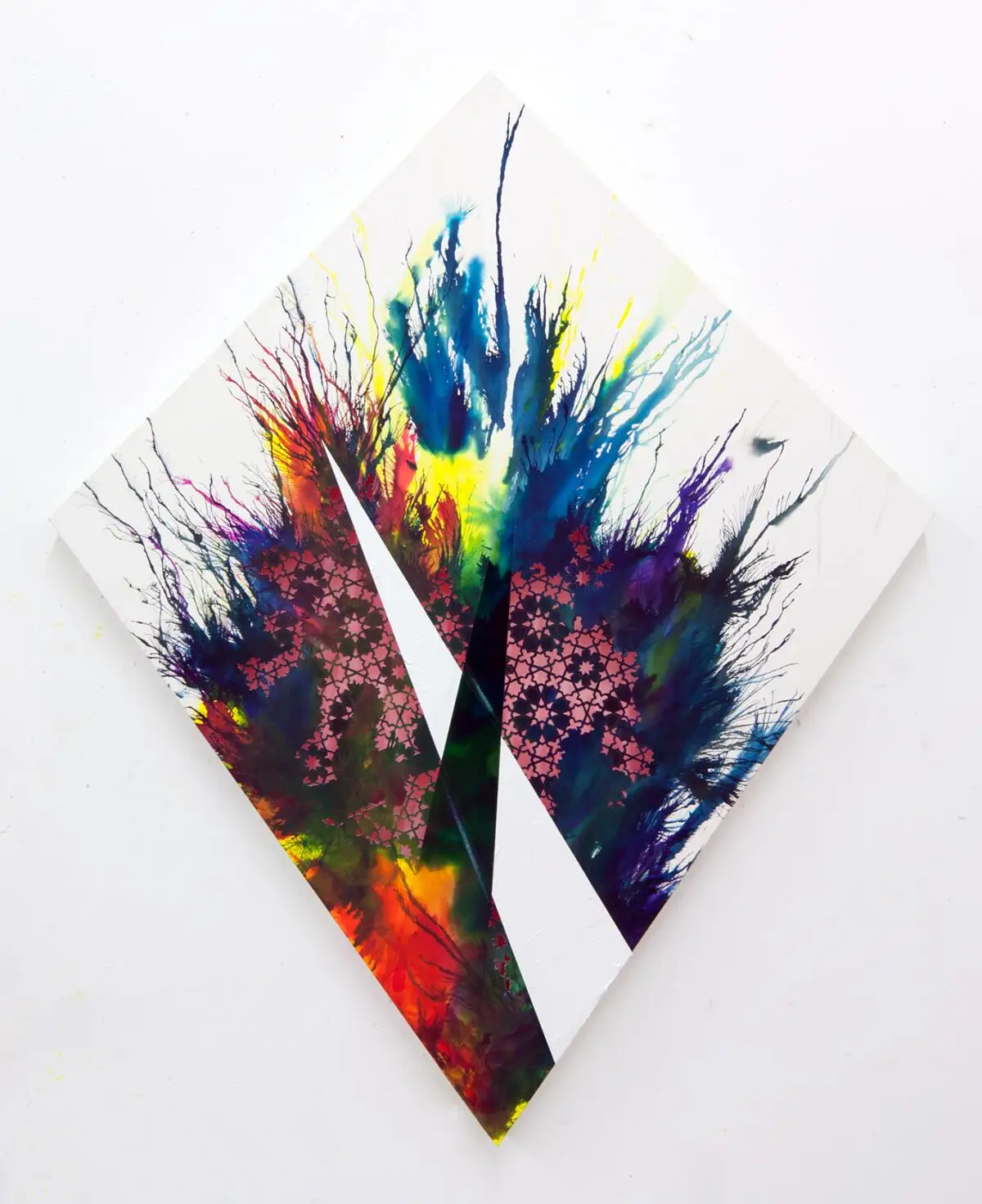 Colorful paint splattered on a white canvas hung diagonally