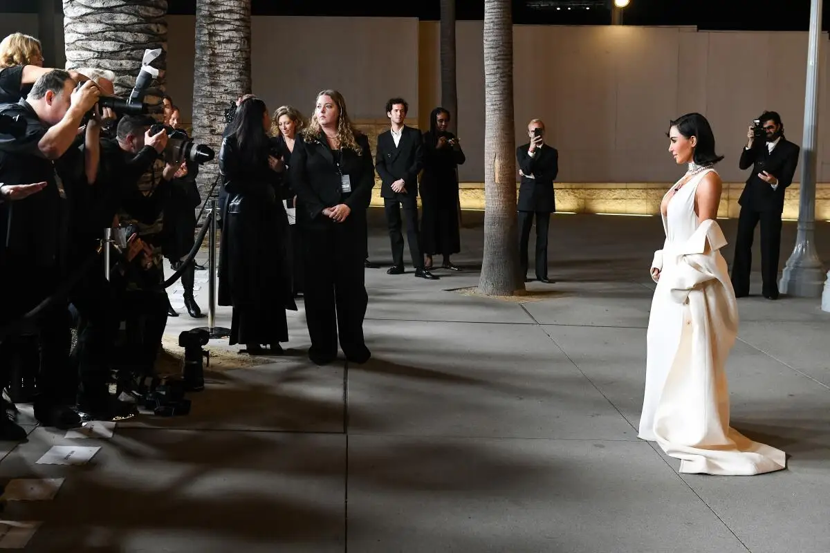 Kim Kardashian, in a white gown, faces photographers at LACMA's Art + Film Gala