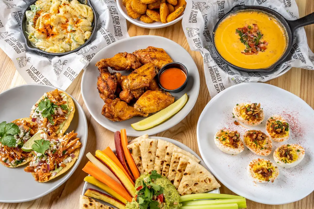 A tables with rotisserie chicken, deviled eggs, and crudite.