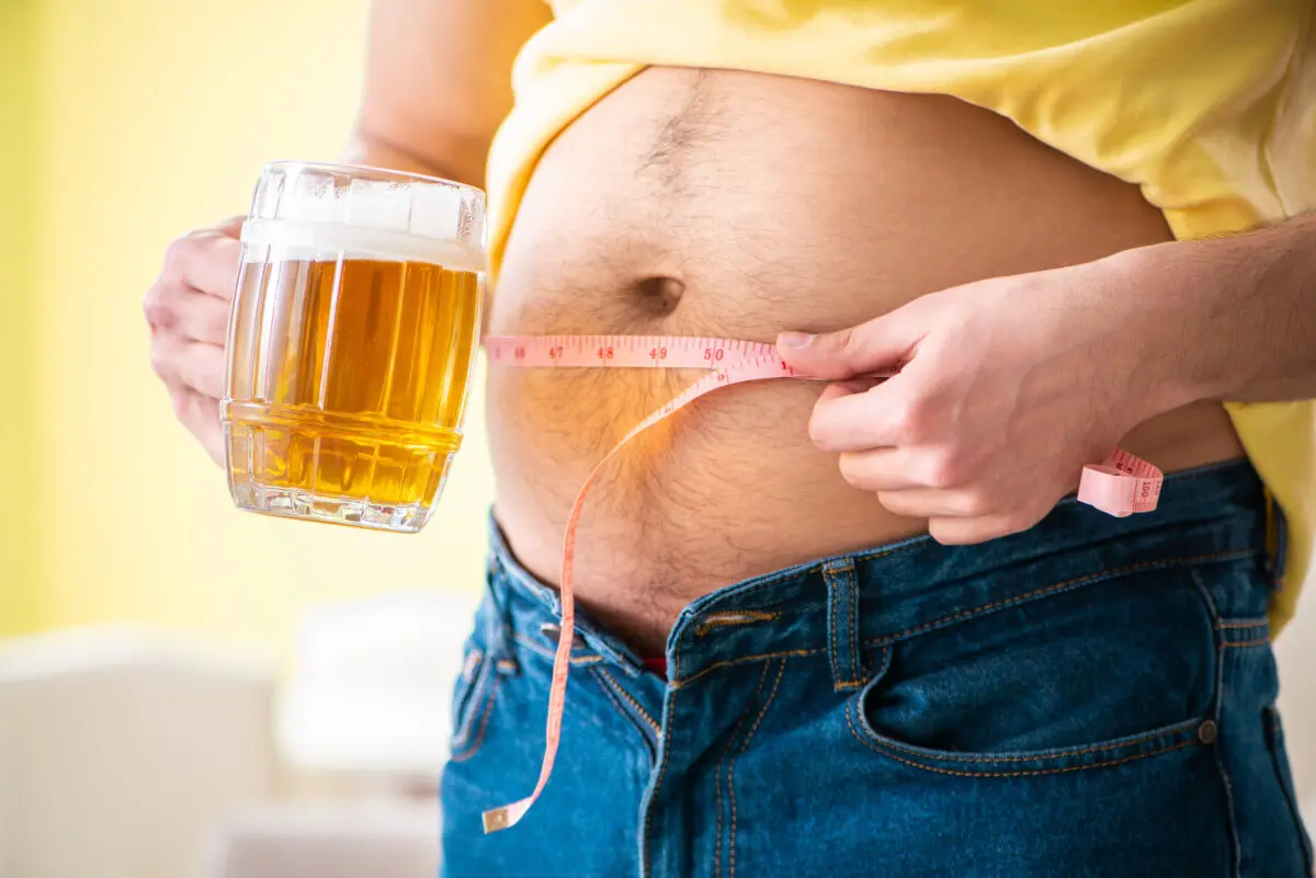 Man measuring body fat with tape measure in dieting concept