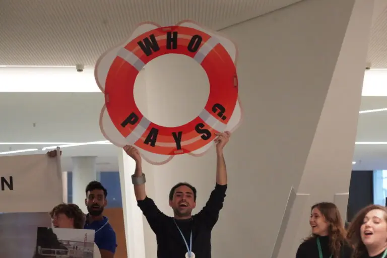 Image shows a man holding up a orange circular buoy