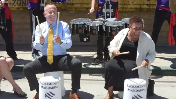 Mayor Darrell Steinberg plays drums with Cassandra Pye of 3.14 Communications at an event in front of the Warehouse Artist Lofts in downtown Sacramento, June 14, 2017. (Photo by Dennis McCoy for Sacramento Business Journal)