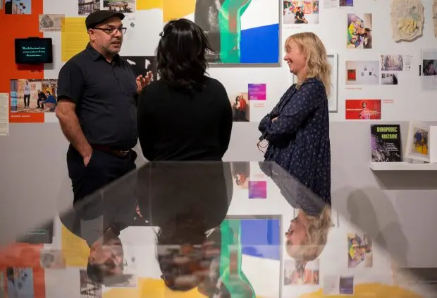 Shaurya Kumar, left, talks to colleagues while looking at artwork at the South Asia Institute in Chicago on Oct. 24, 2024. (Vincent Alban/for the Chicago Tribune)