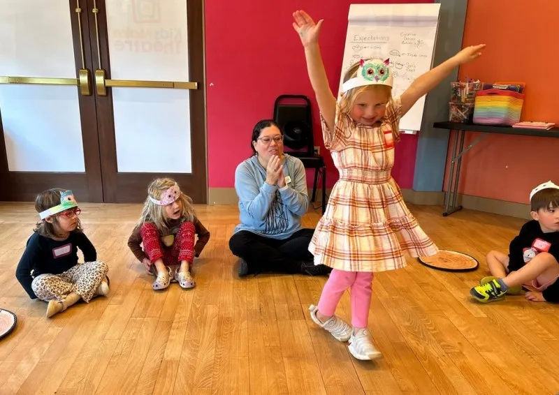 Lori Wilson Honl (center) leads a creative drama club session at Kids Make Theatre in which youngsters made masks to turn themselves into owls. Photo courtesy: Kids Make Theatre