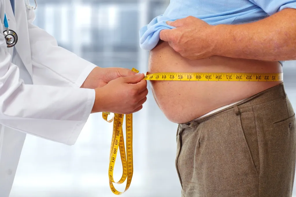 Doctor measuring obese man waist body fat. 