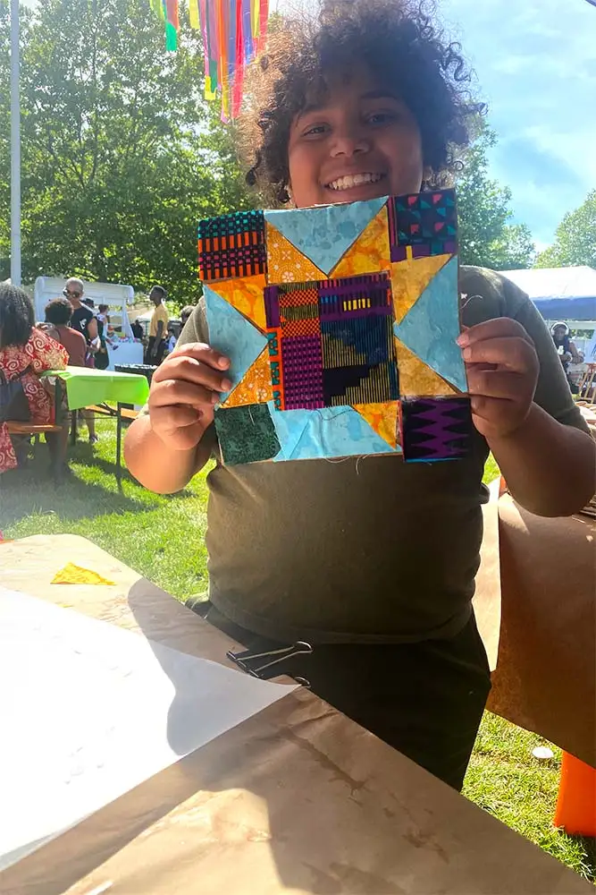 An artists shows off her quit creation at an Oh Sew Powerful event