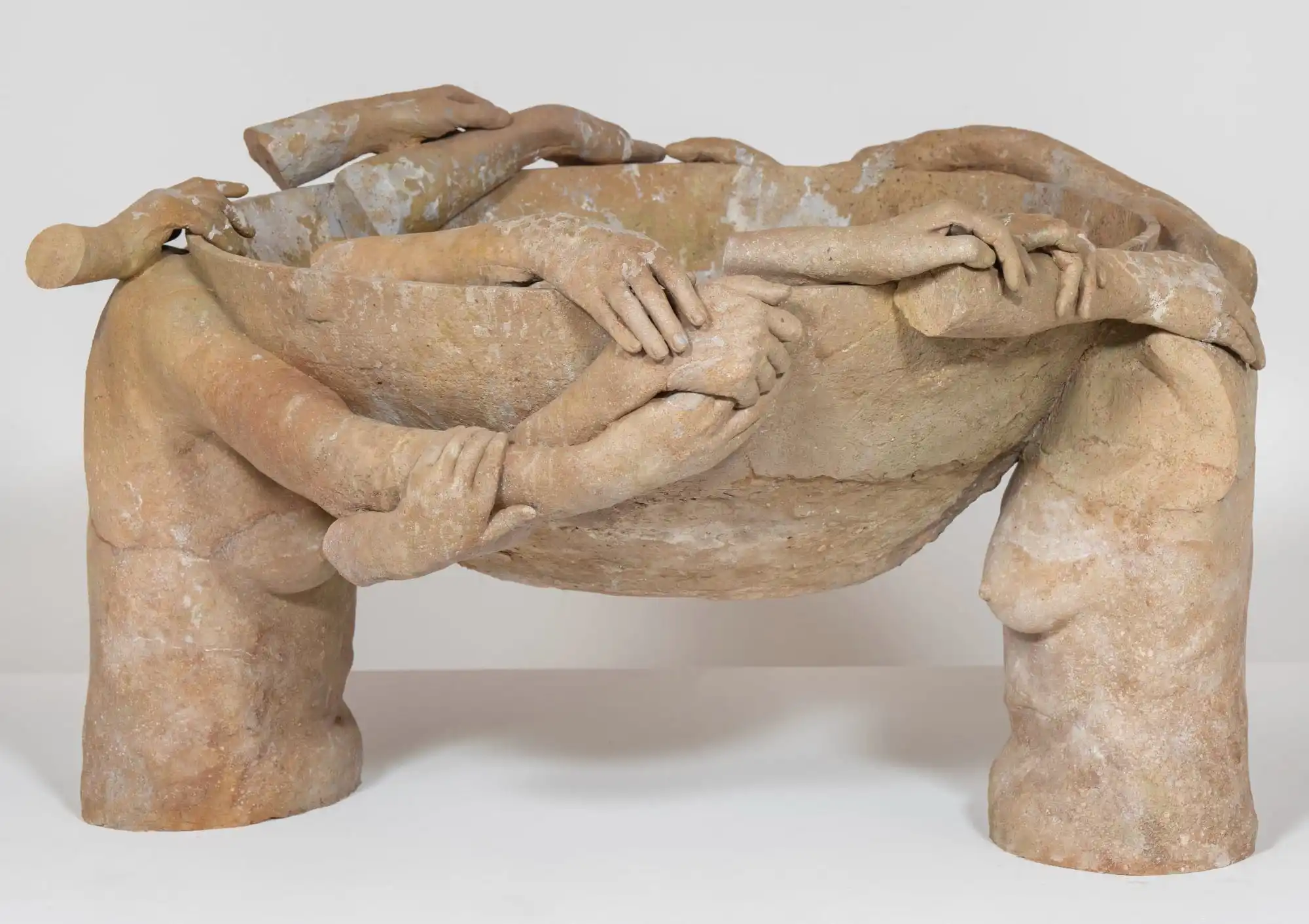 fragmented arms and hands appear to conjoin and hold up a terracotta bowl