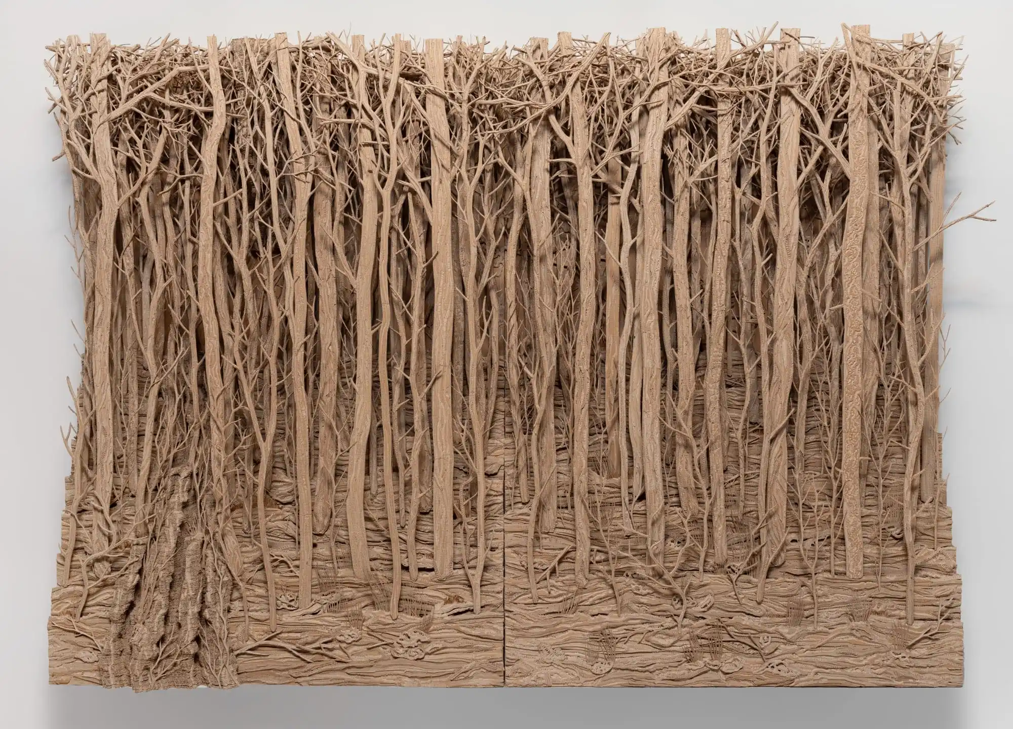 a cardboard wall work of a densely carved forest. All images courtesy of Mariane Ibrahim, shared with permission