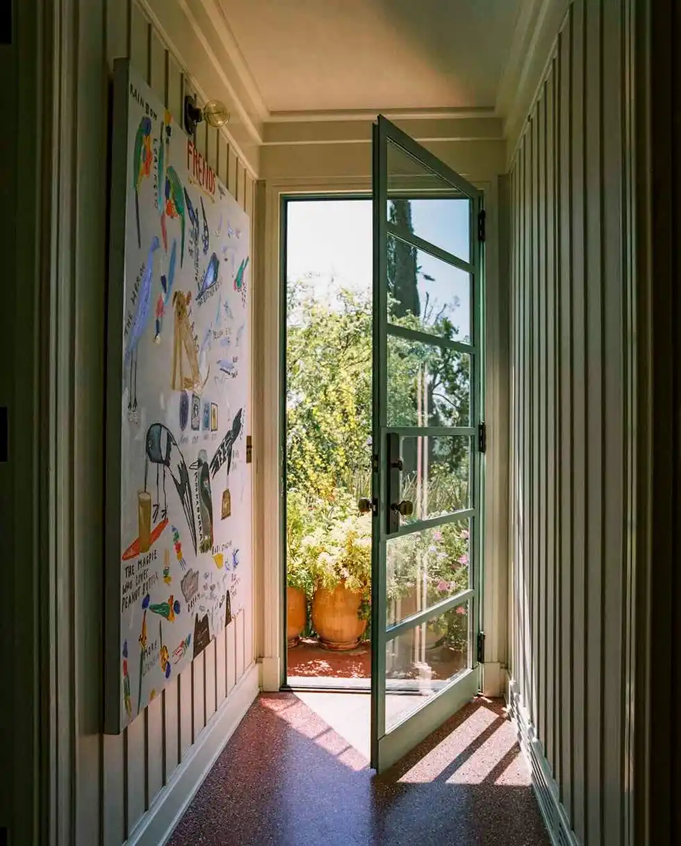 open door leading to a bright outdoor area adorned with plants