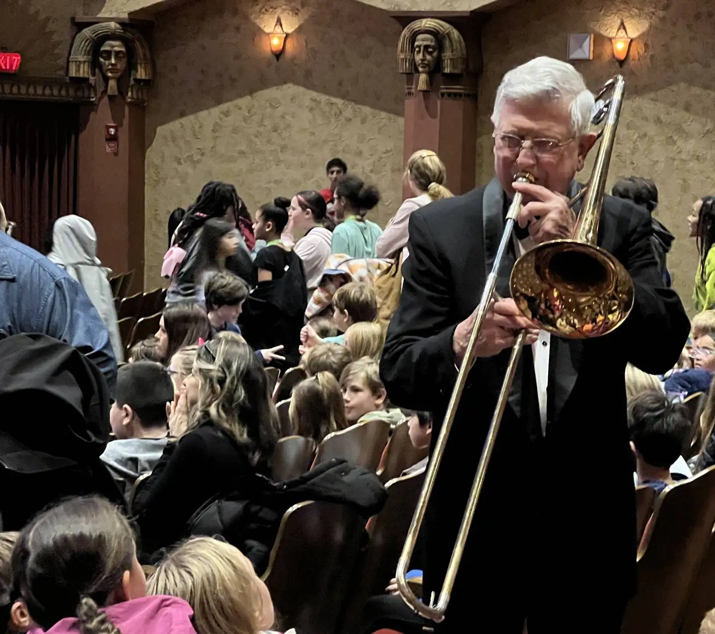 John Smith, a member of the Kishwaukee Symphony Orchestra, on Nov. 15, 2025 plays his trombone for DeKalb County elementary school students inside the Egyptian Theatre in DeKalb.