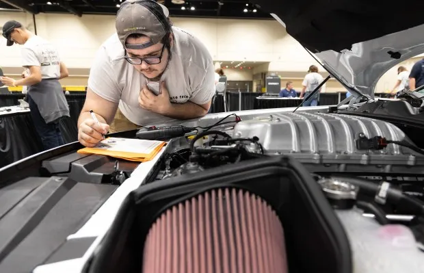 Lyman High School senior, Andrew Mignone, 17, attempts to diagnose mechanical issues with the Dodge Charger during the Central Florida high school student's automotive competition during the Central Florida International Auto Show at the Orlando Convention Center in Orlando, Fla., Thursday, Nov. 14, 2024. The students were tasked with identifying and fixing mechanical issues and the top three competitors won a part of the $10,000 in scholarship money at the end of the automotive competition. (Willie J. Allen Jr./Orlando Sentinel)