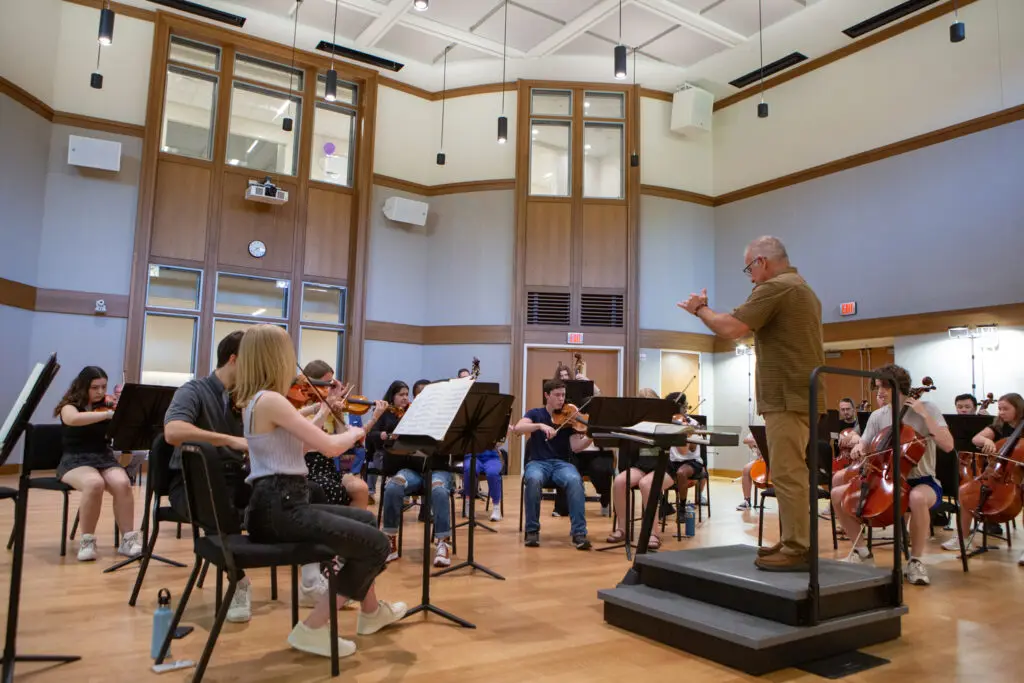 Members of the Lynch family tours the Sarah Rose Hall in Schoenecker Center during an orchestra rehearsal with Professor Matt George and Professor Douglas Orzolek on May 8, 2024, in St. Paul.