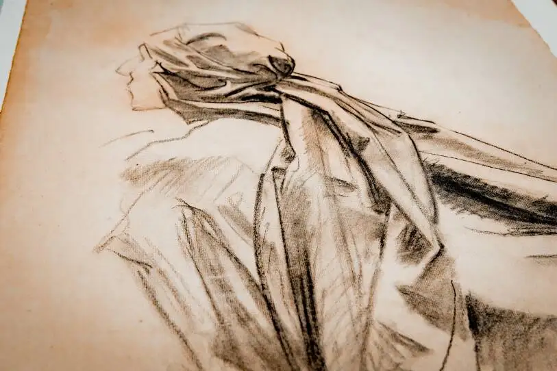 A detailed sketch of a person looking to the left with a headscarf gathered behind the head and a cloak, with shadows accentuting the sketch.