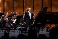 Pianist Adam Jackson acknowledges applause after performing with guest conductor Jim Stopher...