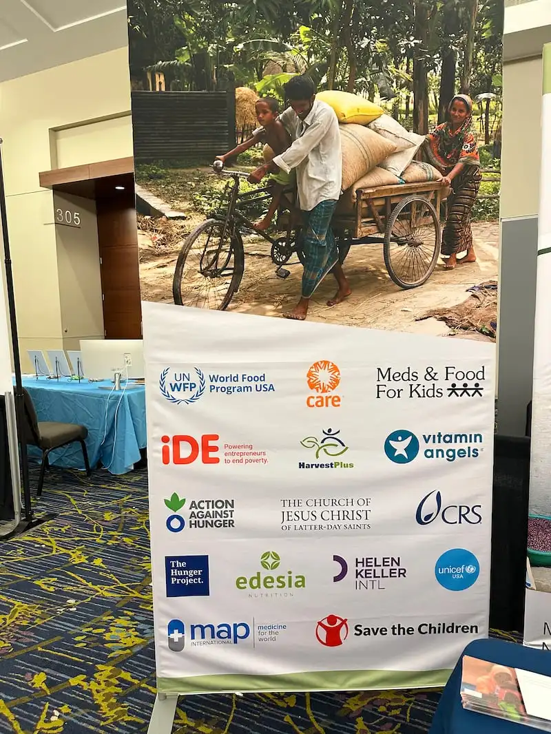 A banner at an information booth from the Church displays the names of nonprofit global organizations collaborating to help child nutrition efforts around the world at the World Food Prize Borlaug International Dialogue, in Des Moines, Iowa, from Oct. 28-31, 2024.