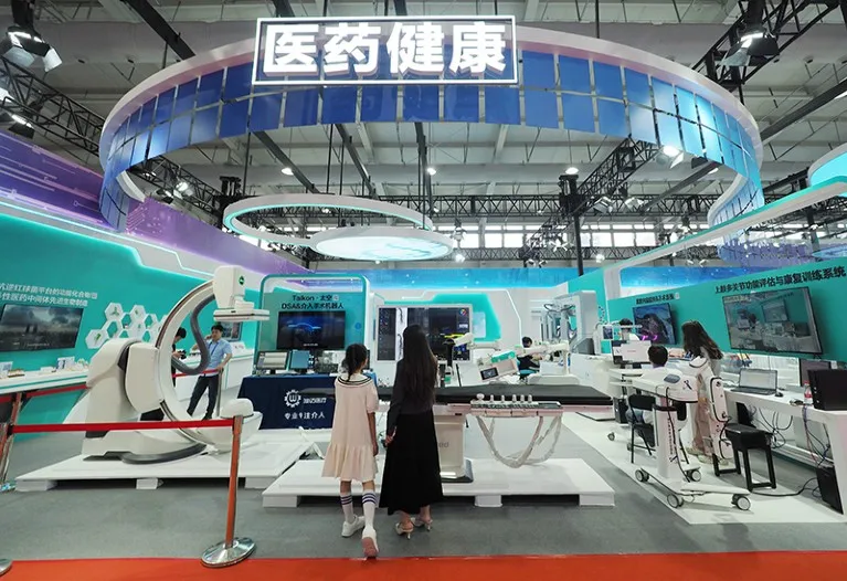 Rear view of a woman and child looking at a neon-lit science exhibition area