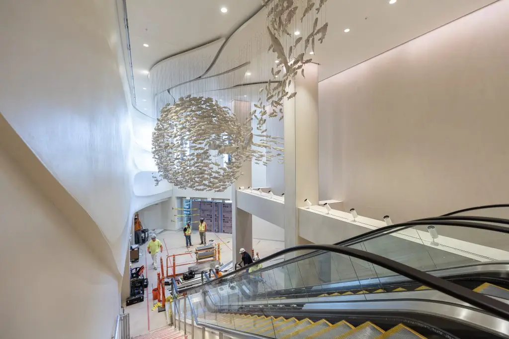 Spherical sculpture installed above escalator descending.