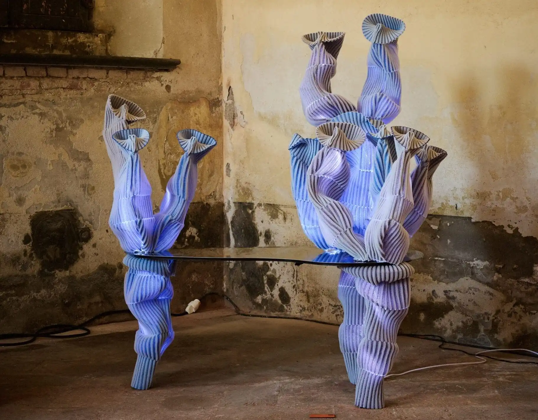 a sculptural table with coral-like forms on each side made from violet-colored woven fabric