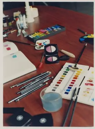 Chanel make-up and coloured paint and pencils on a table